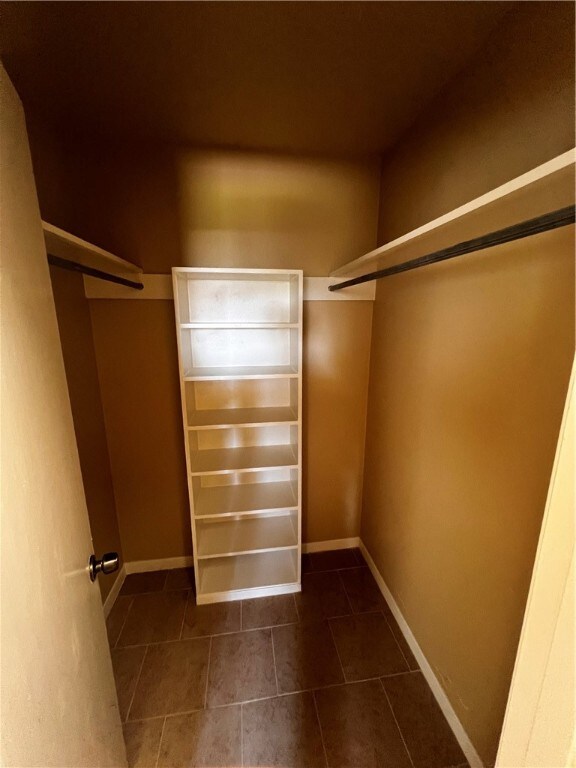 spacious closet with dark tile patterned floors