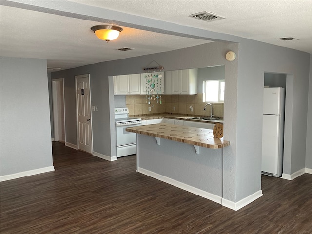 kitchen with white appliances, white cabinets, dark hardwood / wood-style flooring, tasteful backsplash, and sink