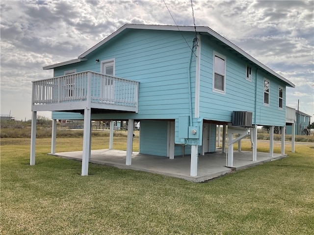 back of property with a patio area, a deck, cooling unit, and a yard