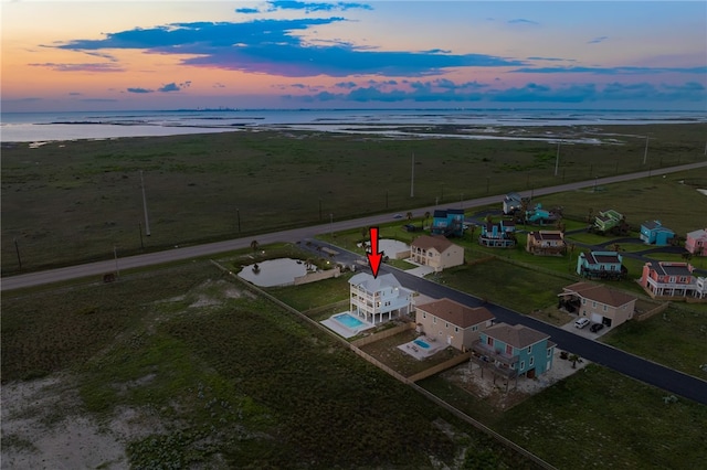 aerial view at dusk with a rural view and a water view