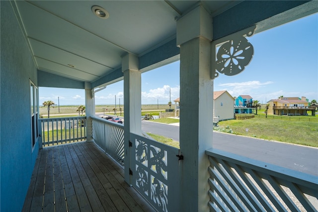 wooden deck featuring a porch and a yard