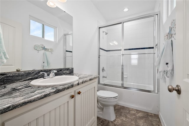 full bathroom with toilet, combined bath / shower with glass door, and vanity