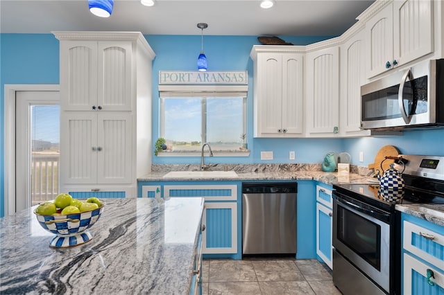 kitchen with stainless steel appliances, a wealth of natural light, sink, and decorative light fixtures