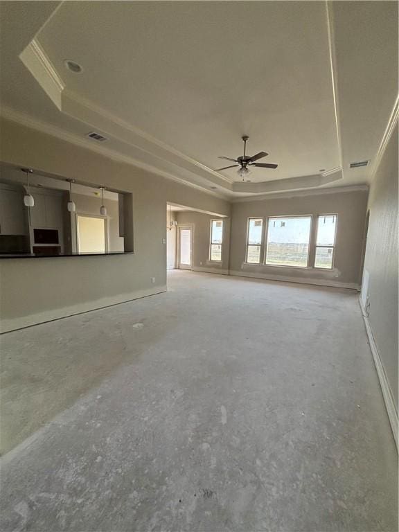 unfurnished living room featuring a raised ceiling, visible vents, and plenty of natural light