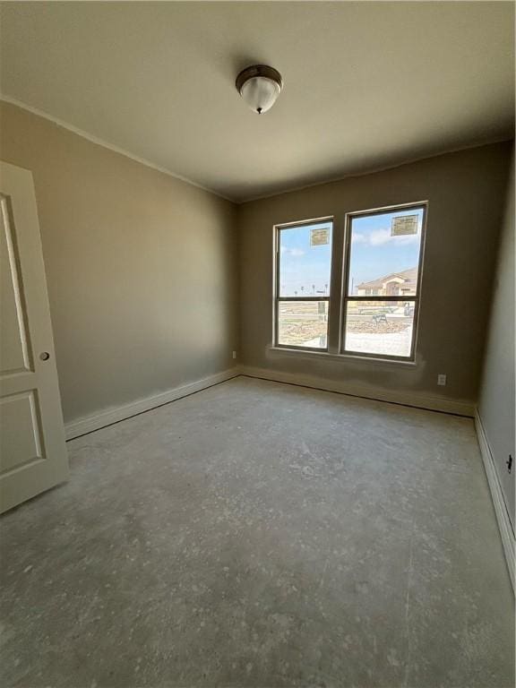 empty room with baseboards and unfinished concrete floors