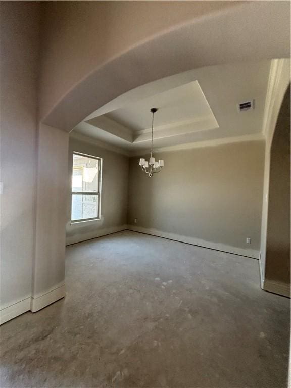 unfurnished room featuring arched walkways, concrete flooring, a notable chandelier, visible vents, and a raised ceiling