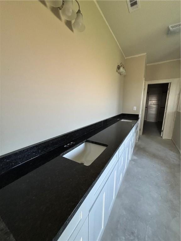 bathroom with crown molding, visible vents, a sink, concrete floors, and a bath