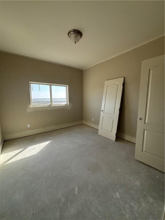 unfurnished bedroom with concrete floors and baseboards