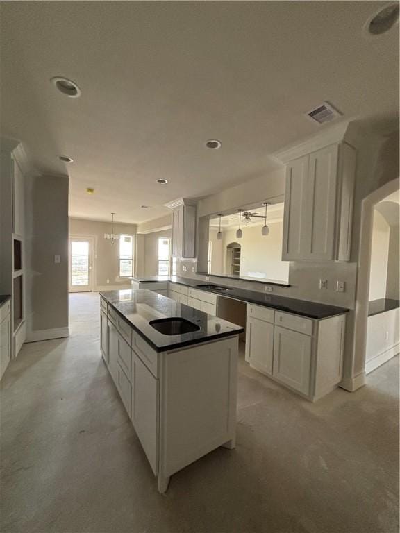 kitchen featuring pendant lighting, dark countertops, visible vents, white cabinets, and a peninsula