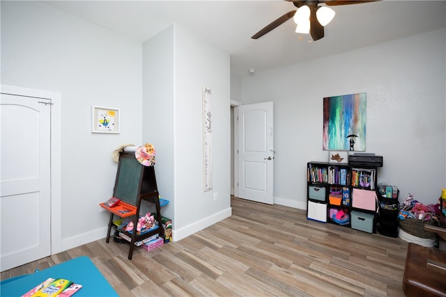 rec room with ceiling fan and light hardwood / wood-style flooring