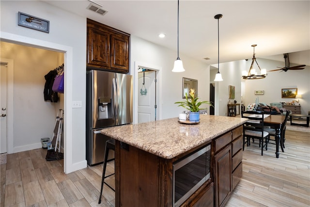 kitchen with stainless steel appliances, hanging light fixtures, light hardwood / wood-style floors, and a center island