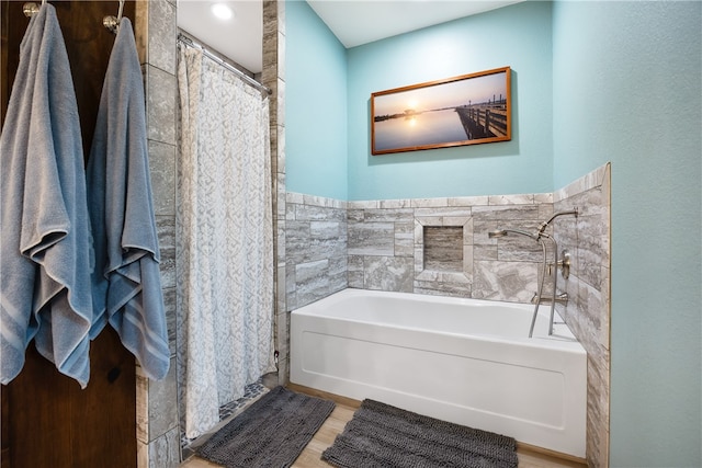 bathroom with tile walls and shower with separate bathtub