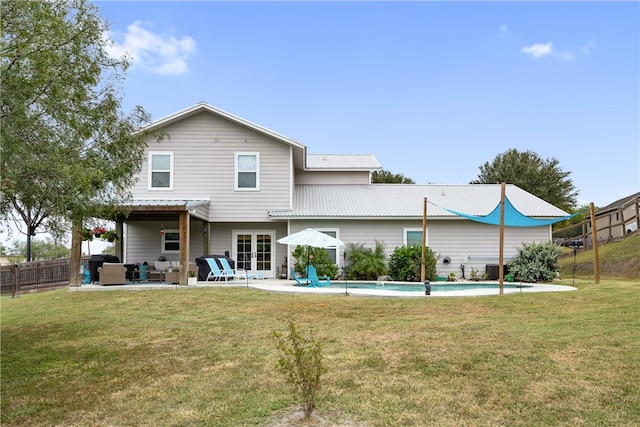 rear view of house featuring a fenced in pool, a patio area, and a yard