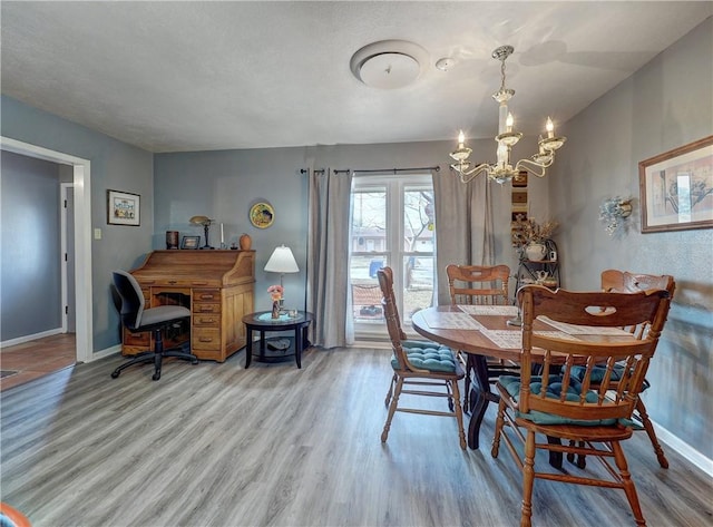 dining space featuring an inviting chandelier and light hardwood / wood-style flooring