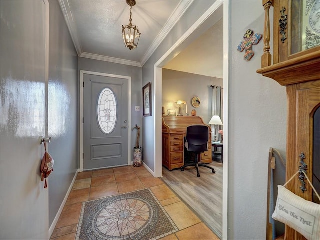 tiled entrance foyer with a notable chandelier and crown molding