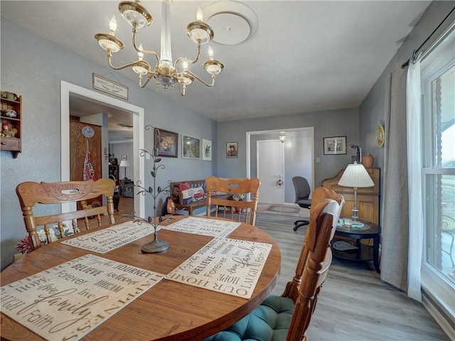 dining area with an inviting chandelier and light hardwood / wood-style floors