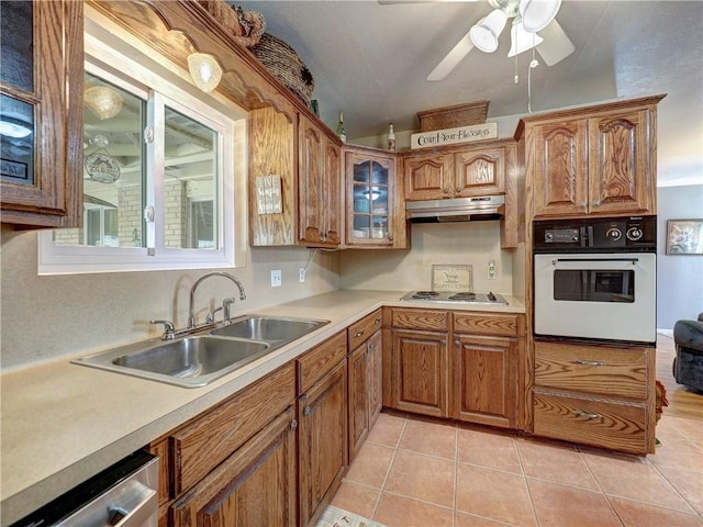 kitchen featuring electric stovetop, sink, oven, stainless steel dishwasher, and light tile patterned floors