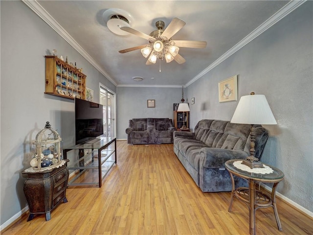 living room featuring ornamental molding, light hardwood / wood-style floors, and ceiling fan