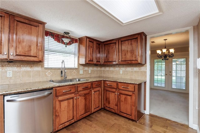4119 Crenshaw Dr, Corpus Christi, TX 78413 - kitchen featuring stainless steel dishwasher, a sink, brown cabinetry, light wood-type flooring, and tasteful backsplash