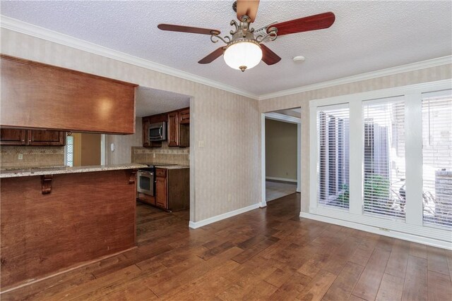 4119 Crenshaw Dr, Corpus Christi, TX 78413 - kitchen featuring stainless steel appliances, dark wood-style flooring, healthy amount of natural light, a ceiling fan, and a textured ceiling