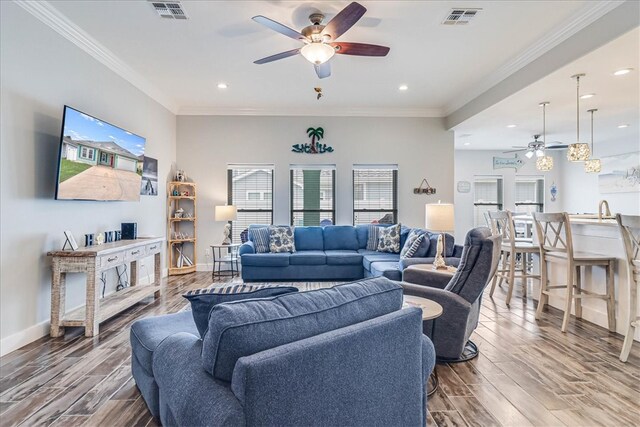 living room featuring sink, hardwood / wood-style flooring, ceiling fan, and crown molding