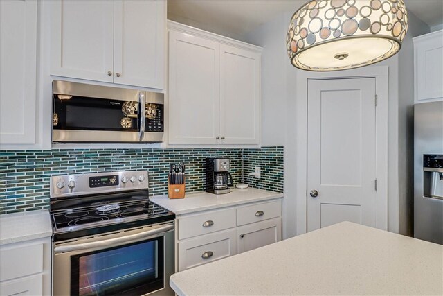 kitchen with white cabinets, decorative backsplash, and appliances with stainless steel finishes