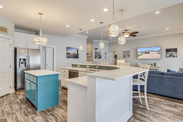 kitchen featuring white cabinetry, hanging light fixtures, stainless steel appliances, and a spacious island