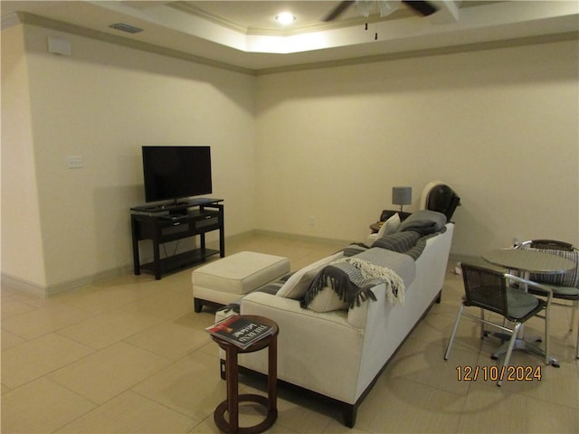 tiled living room featuring a raised ceiling, crown molding, and ceiling fan