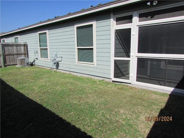 view of side of home with a yard and central AC unit