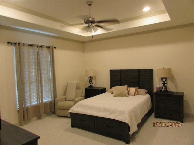 bedroom with a tray ceiling, ceiling fan, light carpet, and ornamental molding