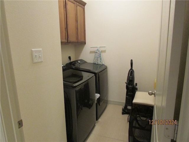 clothes washing area featuring washer and dryer and cabinets