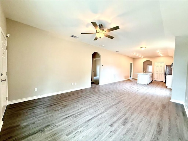 1108 N Staples St, Corpus Christi, TX 78401 - unfurnished living room with arched walkways, ceiling fan, wood finished floors, baseboards, and a sink