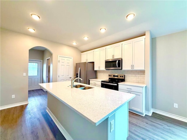 1108 N Staples St, Corpus Christi, TX 78401 - kitchen with stainless steel appliances, a sink, baseboards, arched walkways, and dark wood-style flooring
