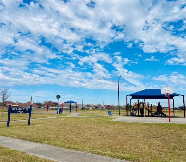 view of property's community featuring basketball court, a yard, and a playground