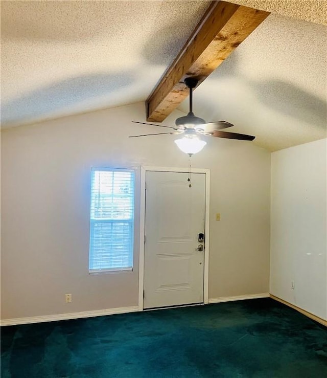 foyer with a textured ceiling, lofted ceiling with beams, dark carpet, and ceiling fan