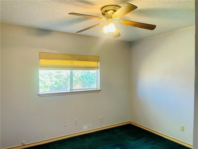 spare room with ceiling fan, a textured ceiling, and dark colored carpet