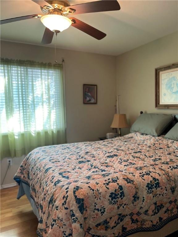 bedroom with ceiling fan and light wood-type flooring