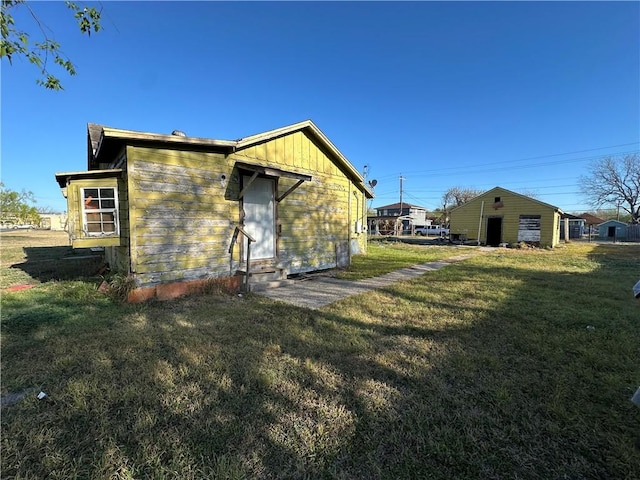 back of property with a lawn, entry steps, and board and batten siding