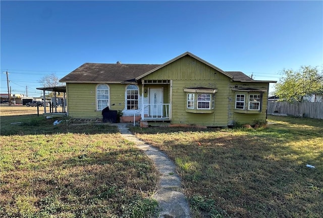 view of front of house with a front yard and fence