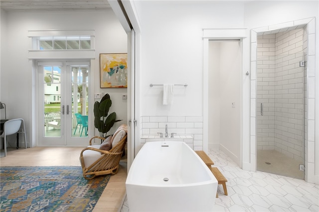 bathroom featuring french doors and separate shower and tub