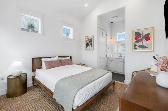 carpeted bedroom with ensuite bath, lofted ceiling, multiple windows, and a closet