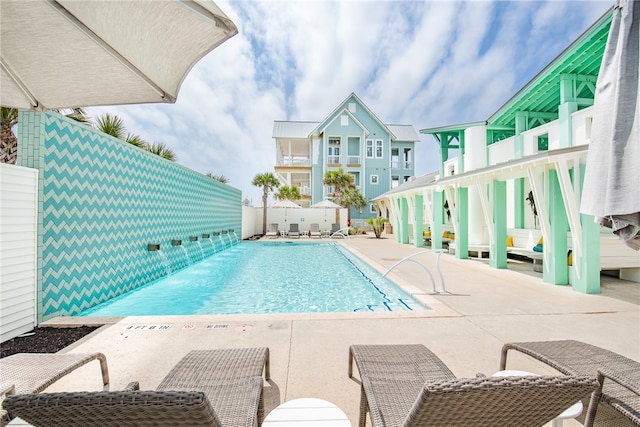 view of swimming pool with pool water feature and a patio area