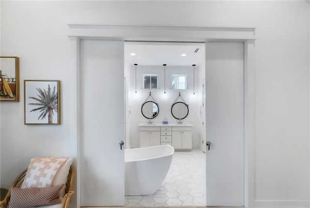 bathroom featuring a tub to relax in, vanity, and tile patterned floors