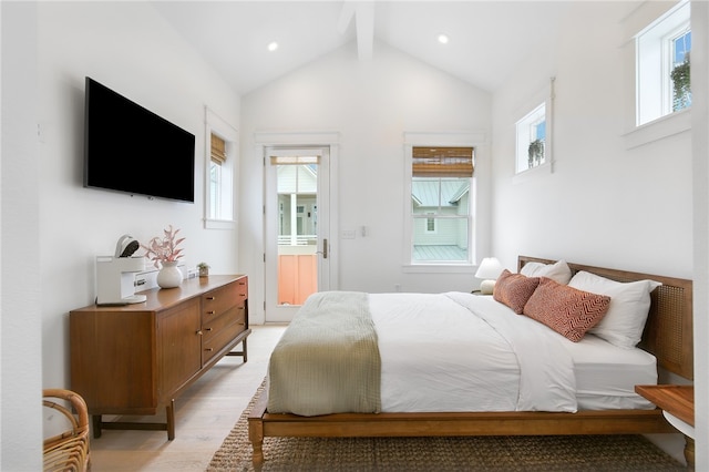 bedroom with lofted ceiling with beams and light wood-type flooring