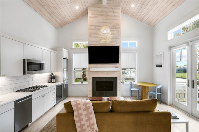 kitchen featuring wooden ceiling, appliances with stainless steel finishes, high vaulted ceiling, light hardwood / wood-style flooring, and white cabinets