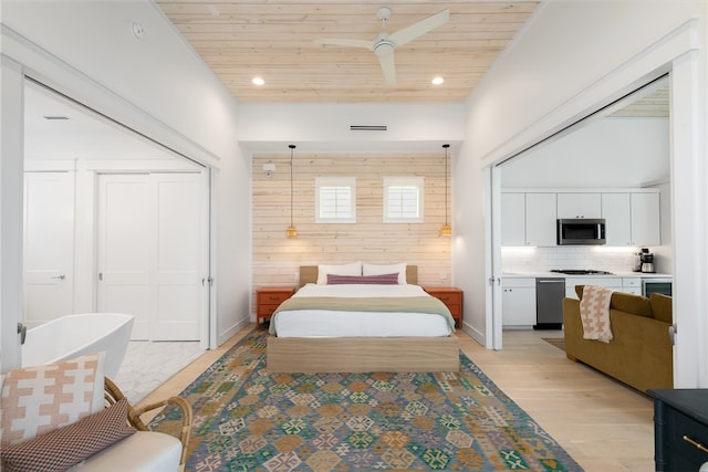 bedroom with ceiling fan, wood ceiling, light hardwood / wood-style flooring, wooden walls, and a closet