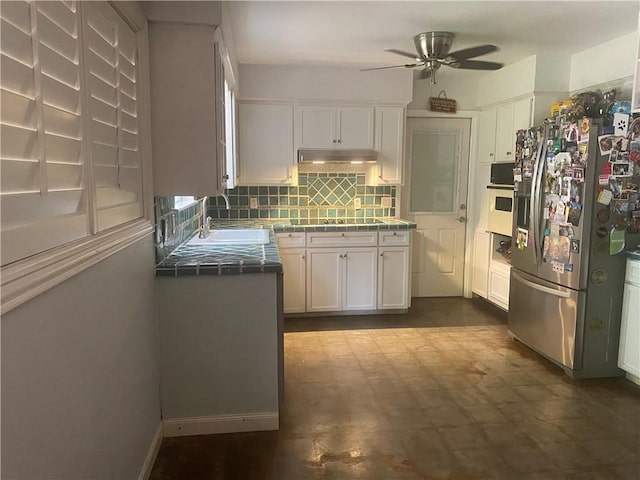 104 Park Pl, Portland, TX 78374 - kitchen featuring stainless steel fridge, tile counters, white cabinetry, and white oven
