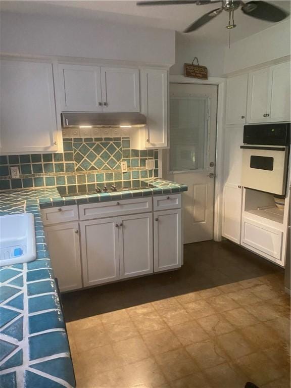 104 Park Pl, Portland, TX 78374 - kitchen with white oven, tile countertops, and white cabinetry