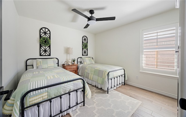 bedroom with a ceiling fan, baseboards, and wood finished floors