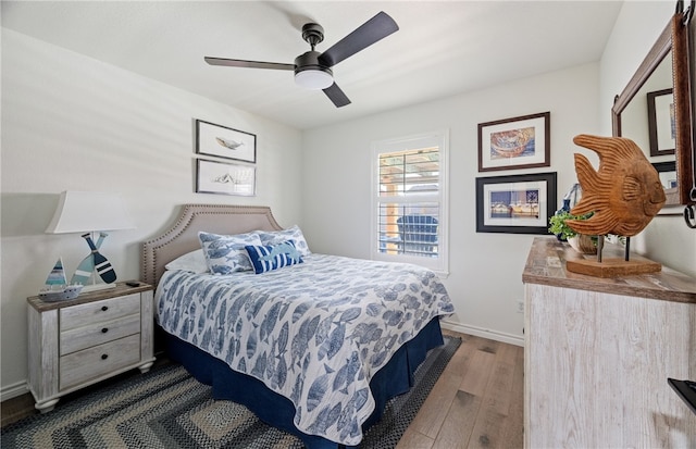 bedroom featuring ceiling fan, wood finished floors, and baseboards